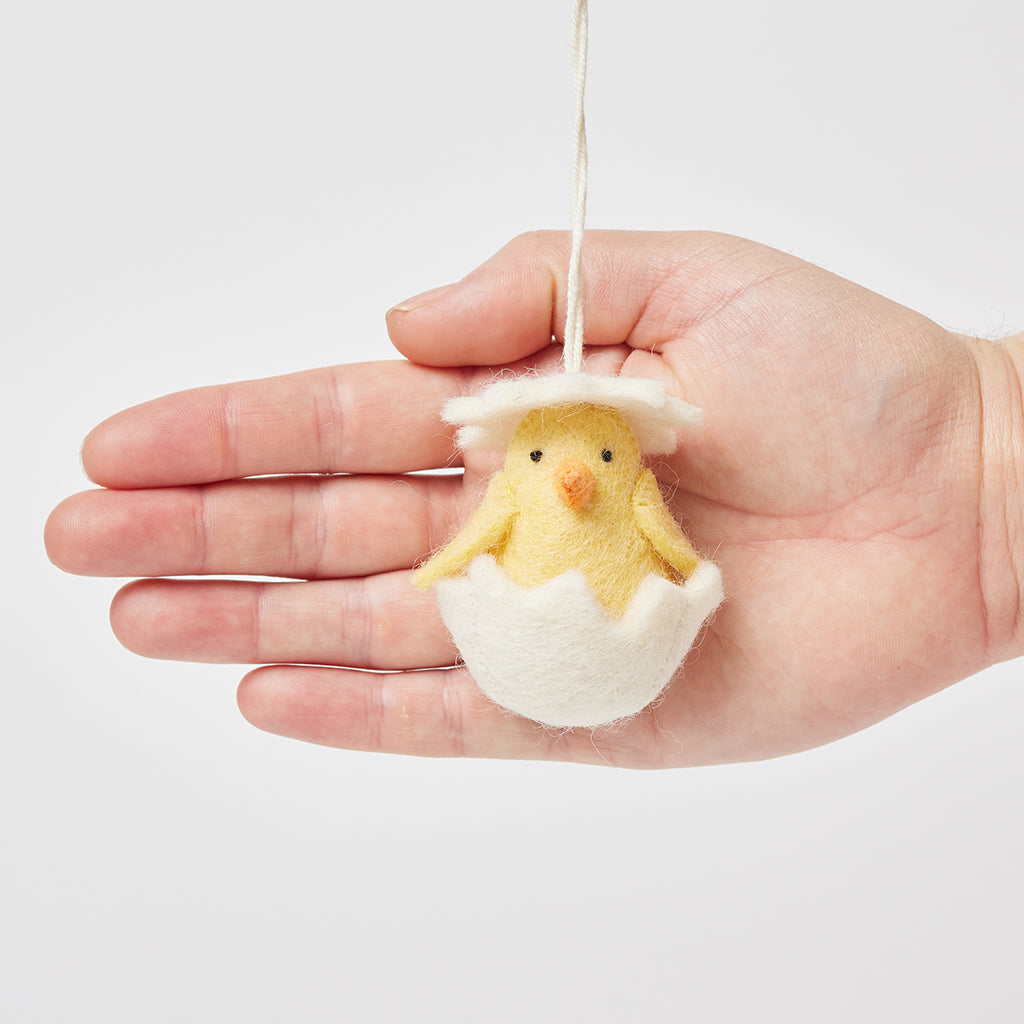Ornement de poussin éclos dans une coquille blanche